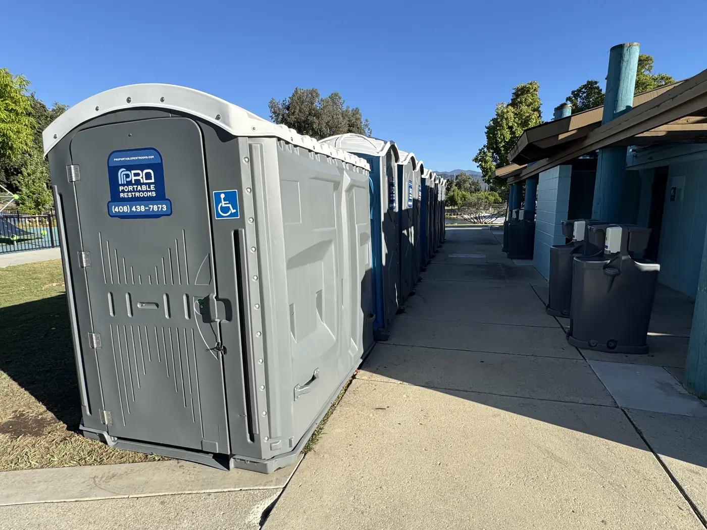 An ADA-accessible Pro Portable Restrooms unit at the end of the row at a San Jose park