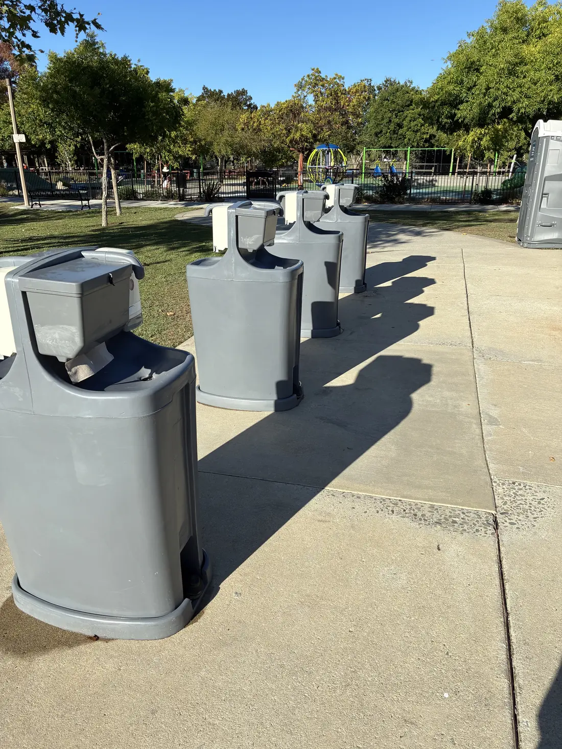 Foot-pump hand-wash stations on a park walkway in San Jose