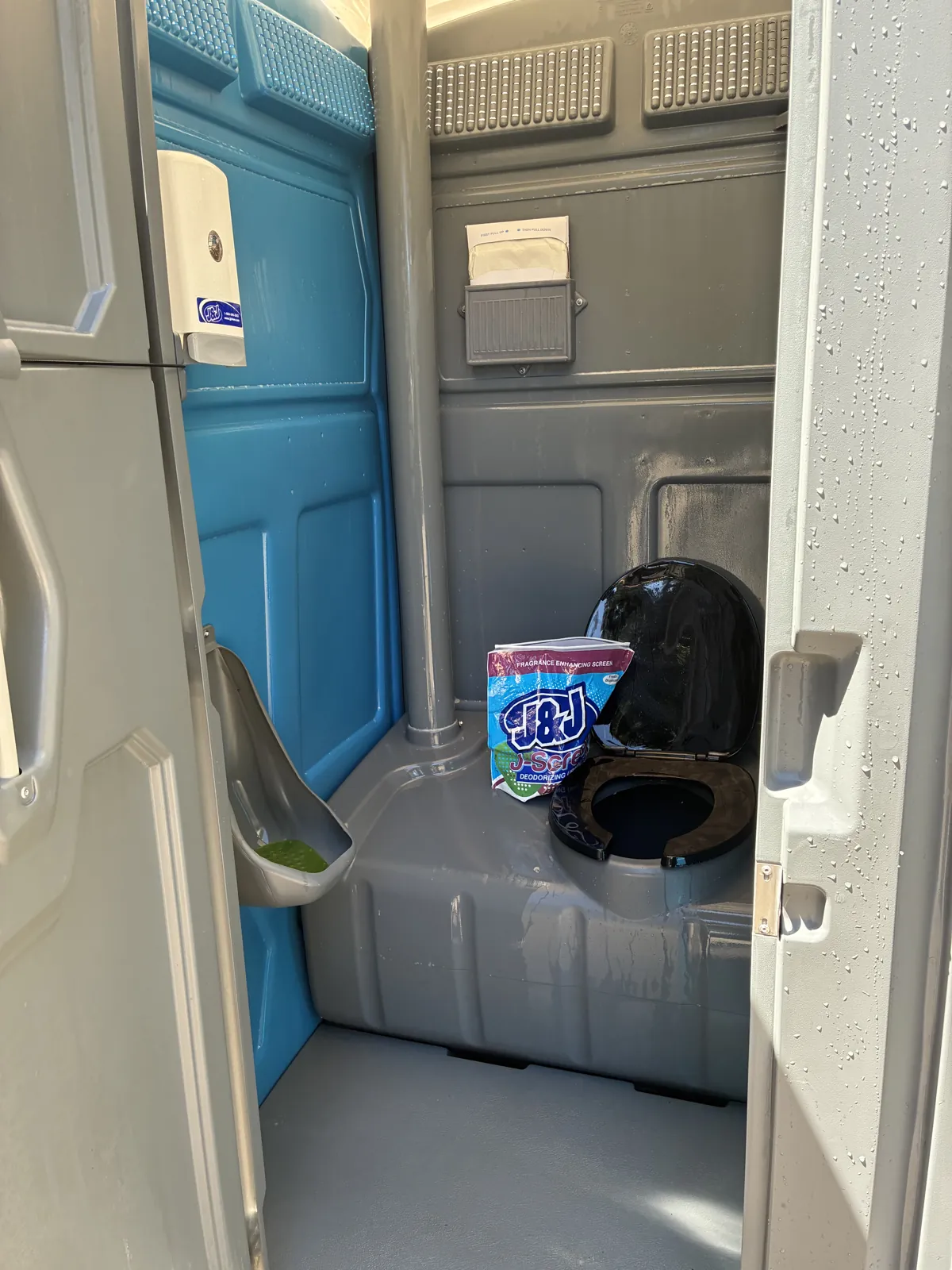 The freshly cleaned interior of a Pro Portable Restrooms unit prepped with deodorizer and a stocked dispenser